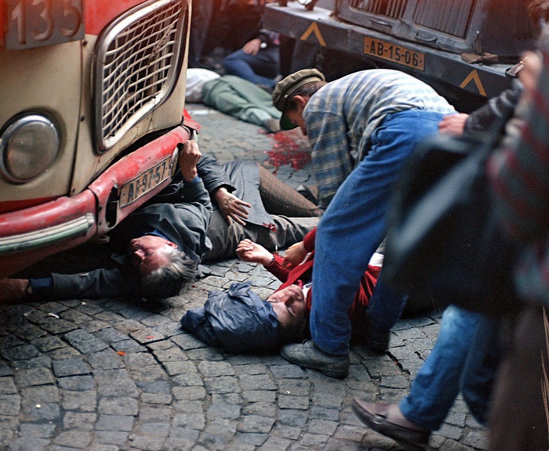 Водитель автобуса пытается помочь раненым во время стрельбы у здания Чехословацкого радио