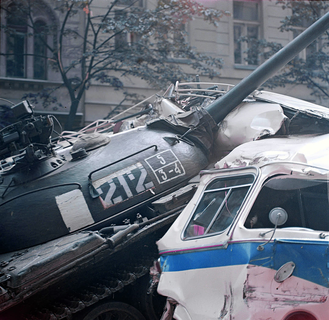 Танк наезжает на баррикады, сделанные из машин и автобусов, возле здания Чехословацкого радио