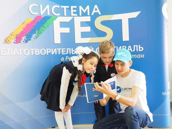 Волонтер фестиваля, ведущий инженер ДМТС ООО «Башкирэнерго» Ильдар Рыскулов знакомит детей с программой мероприятия