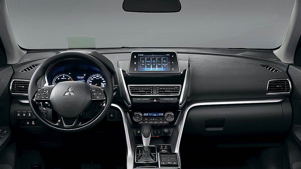 Теперь и у Mitsubishi есть удобный проекционный head-up дисплея, а также возвышающийся над передней панелью широкий цветной экран, выполненный в стиле европейских конкурентов. Насколько удобен новый новый тачпад-интерфейс покажет опыт эксплуатации, привыкнуть к нему за пару дней теста не получилось.