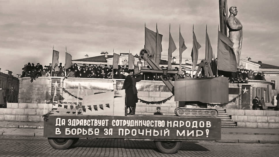 Агитационный автомобиль на фоне памятника И.В. Сталину на площади 1905 года в Свердловске. Какое отношение к «борьбе за прочный мир» имеет экскаватор? Вероятно, то, что до экскаваторов на Уралмашзаводе производили танки Т-34. Под декорациями узнается грузовик ЗИС-5