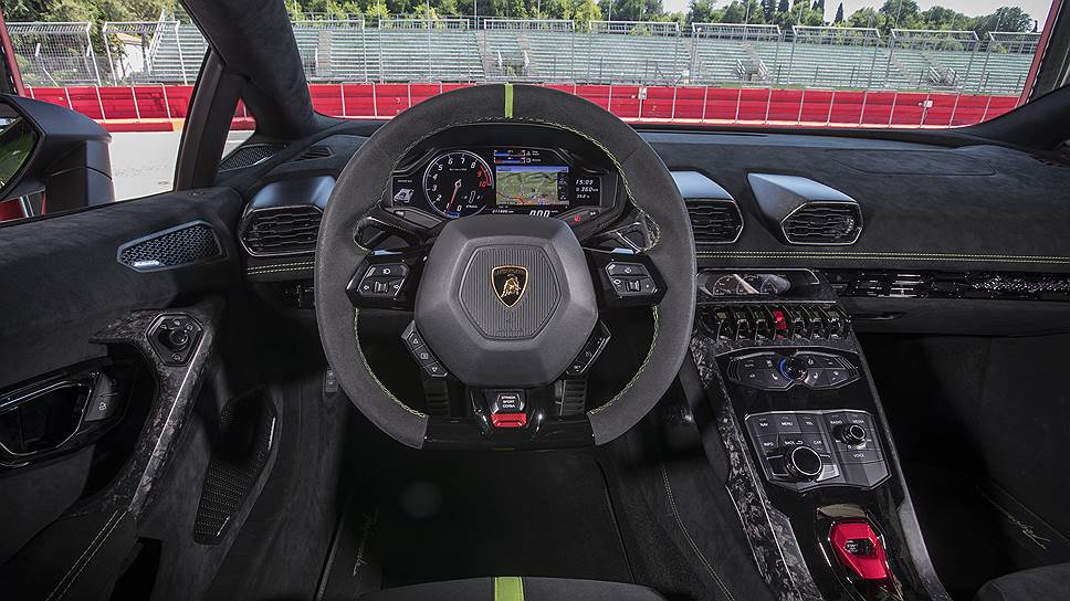 Кокпит Lamborghini Huracan Performante напоминает кабину сверхсовременного истребителя. В том числе, благодаря множеству кнопок и тумблеров. Так, за переключение режимов отвечает красный тумблер, расположенный в нижней части рулевого колеса.