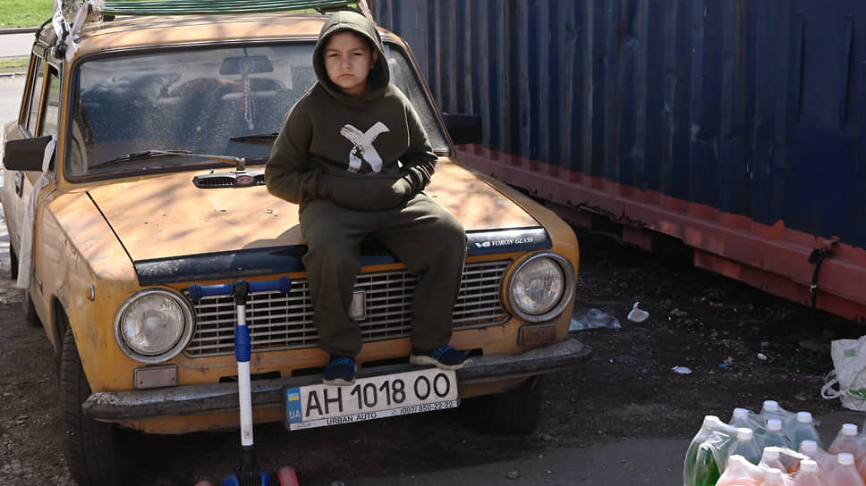 Мальчик сидит на капоте старой «Копейки» в Мариуполе