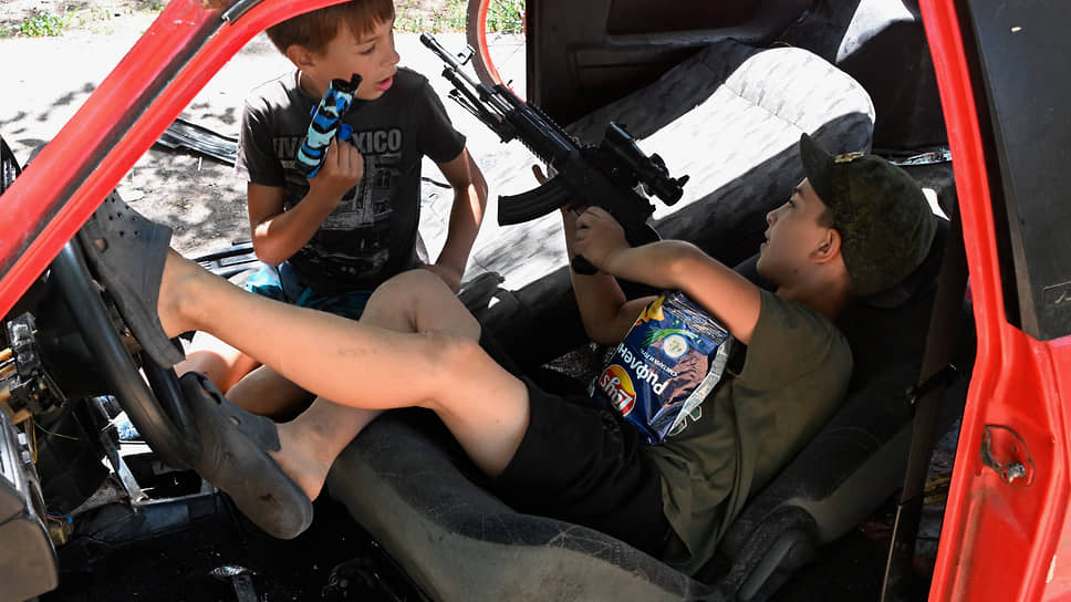 Дети играют в салоне разбитого автомобиля, Мариуполь