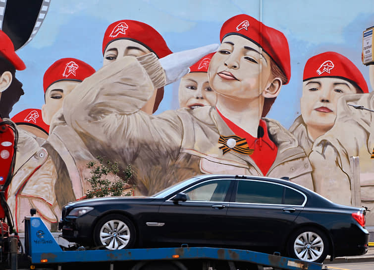 BMW 7 Серии увозят на эвакуаторе на фоне мурала с изображением юнармейцев в Москве  