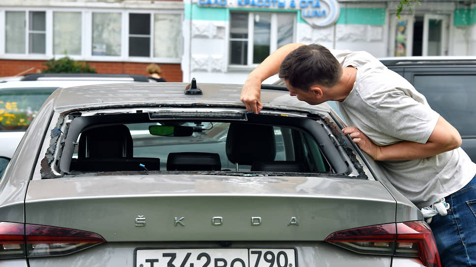 Владелец осматривает выбитое стекло багажника своего автомобиля, поврежденного в процессе ликвидации двух беспилотников в Красногорске