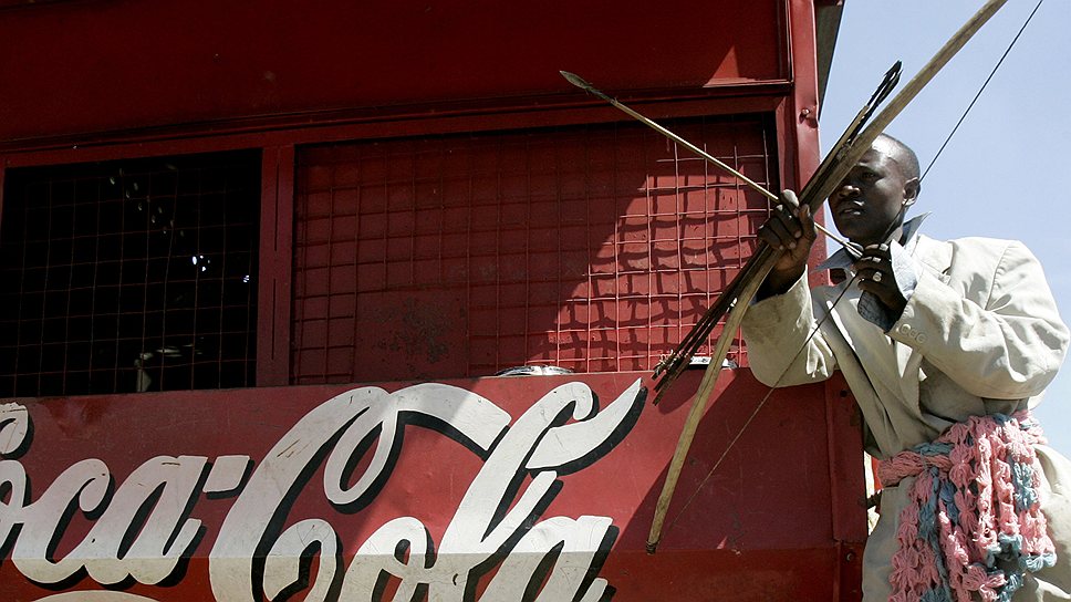 Сегодня напиток продается более чем в 200 странах мира. 
&lt;br>На фото: представитель племени Календжин в Кении рядом с киоском с логотипом Coca-Cola