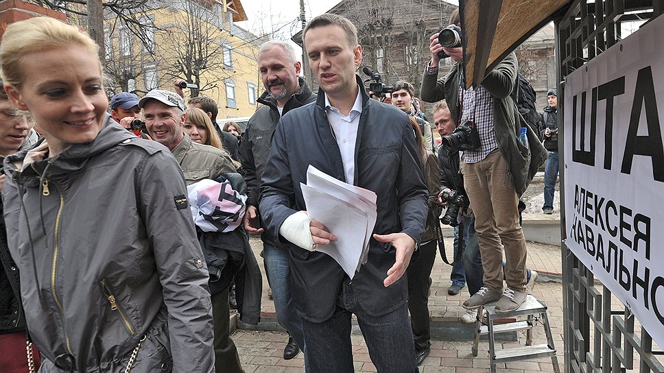 Председатель Координационного совета оппозиции Алексей Навальный (в центре) с супругой Юлией (слева) по дороге в штаб сторонников Алексея Навального, 2013 год 