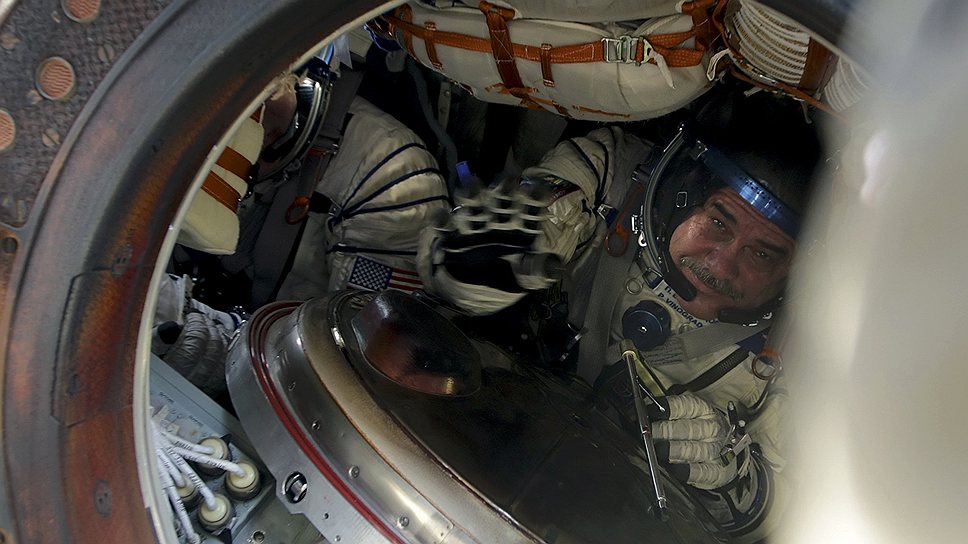 Специалисты поисково-спасательных групп эвакуируют приземлившихся космонавтов