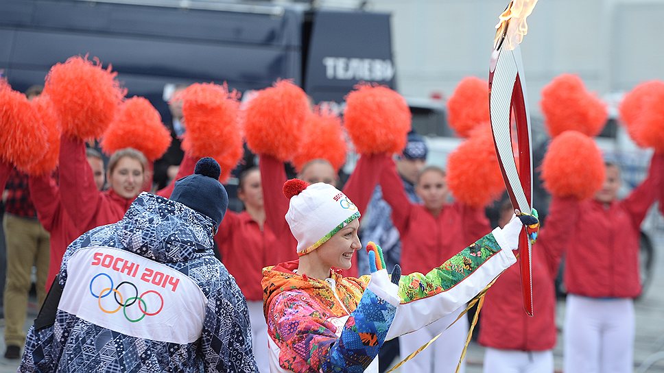 Четырехкратная олимпийская чемпионка по синхронному плаванию Анастасия Давыдова (в центре) несет олимпийский огонь 