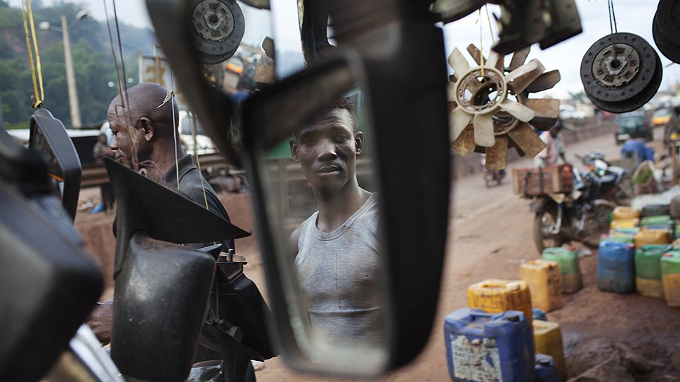 Продавец в зеркале машины Peugeot в Мали