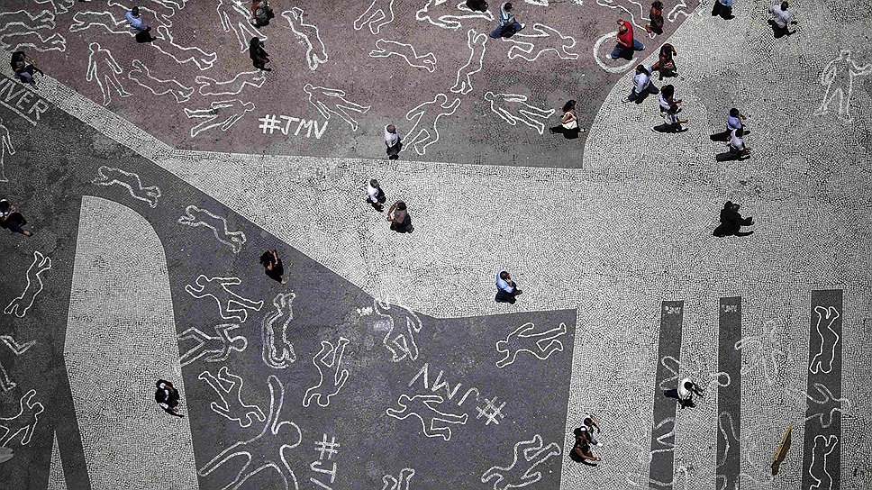 Люди рисуют схемы тел во время протеста  в центре города Рио-де-Жанейро. Рисунки изображают 4 тыс. жертв насилия, которые умерли в Рио в 2012 году 