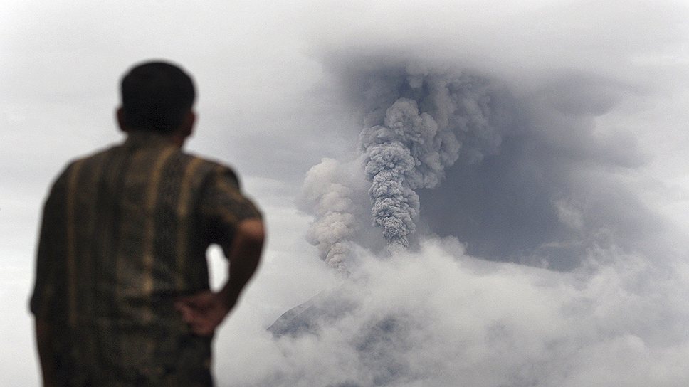Человек смотрит на извержение вулкана Синэбанг в Северной Суматре, Индонезия. Приблизительно 15 тыс. человек были эвакуированы из 17 деревень вокруг вулкана 