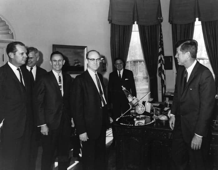 США также начали изучение Марса в 1960-х годах. Аппарат NASA Mariner 4 был запущен 28 ноября 1964 года и стал первым космическим аппаратом, передавшим фотографии Марса. В дальнейшем Mariner 4 работал на околосолнечной орбите, связь с ним прекратилась в декабре 1967 года &lt;br>
На фото: директор лаборатории реактивного движения NASA Уильям Пикеринг (в центре) представляет модель космического корабля «Маринер» президенту Джону Кеннеди (справа)