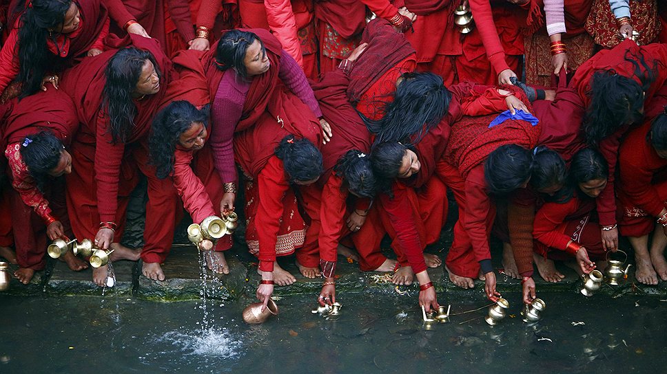 Непальские индуисты наполняют кувшины водой из реки Багмати у храмового комплекса Пашупатинатх, которая считается святой
