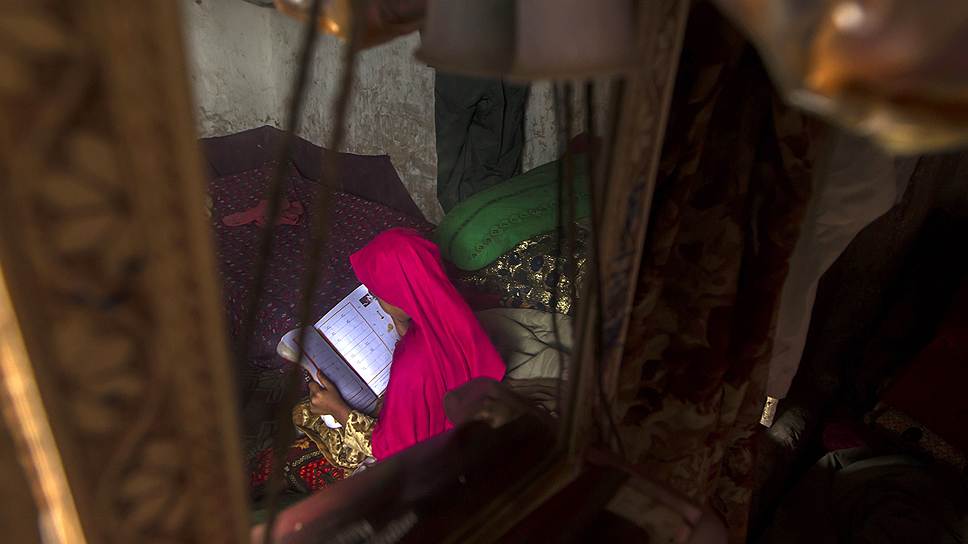 На фото девочка из трущоб делает школьное домашнее задание