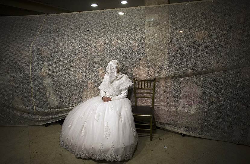 Невеста наблюдает за танцем жениха во время традиционной свадебной церемонии в Иерусалиме