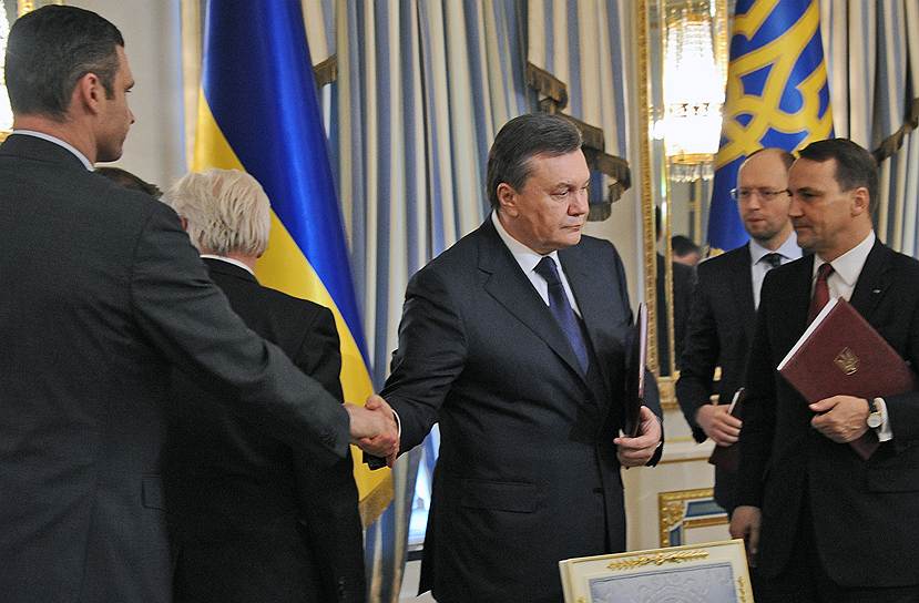 Президент Украины Виктор Янукович (в центре) и лидеры оппозиции Виталий Кличко (слева) и Арсений Яценюк (справа на заднем плане) после подписания соглашения об урегулировании политического кризиса на Украине