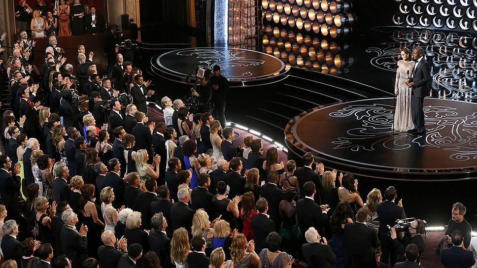 Зрители стоя приветствуют актеров Анджелину Джоли и Сидни Пуатье, которые вручают «Оскар» за лучшую режиссуру