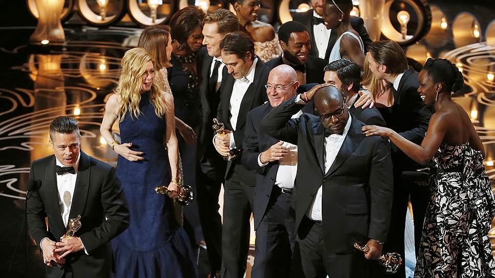 Режиссер «12 лет рабства» Стив МакКуин (справа), продюсер картины, также исполнивший в ней роль второго плана Брэд Питт (крайний слева) и съемочная группа получают «Оскар» за лучший фильм года