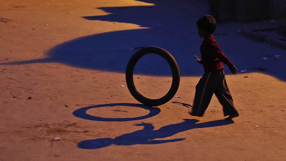 Мальчик, играющий с шиной в Нью-Дели