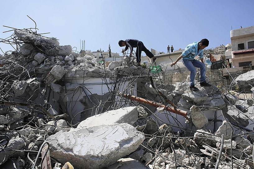 Палестинские дети на руинах нелегально возведенного дома в Восточном Иерусалиме, снесенного городскими властями