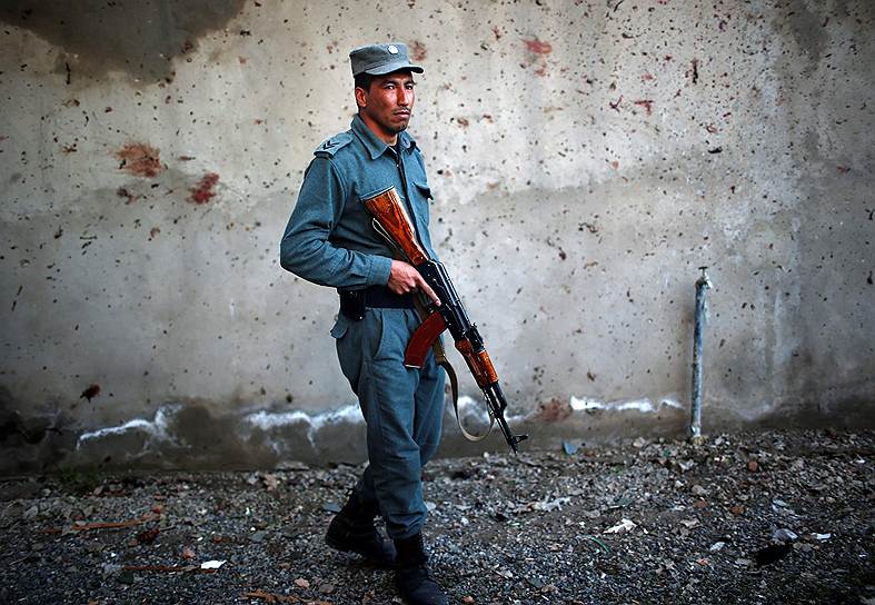 Полицейский возле здания избирательной комиссии в Кабуле после атаки боевиков