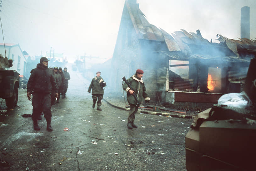 Аргентинские военнопленные около горящего здания в Порт-Стэнли