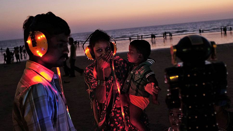 Реакция женщины на слова электронного предсказателя судьбы на пляже в Мумбаи