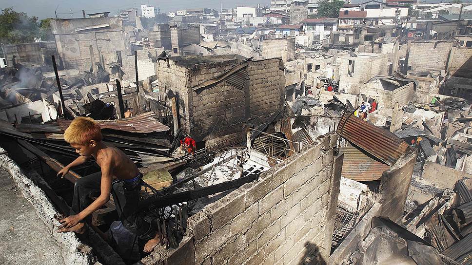 Руины домов, сгоревших во время сильного пожара в районе трущоб Манилы