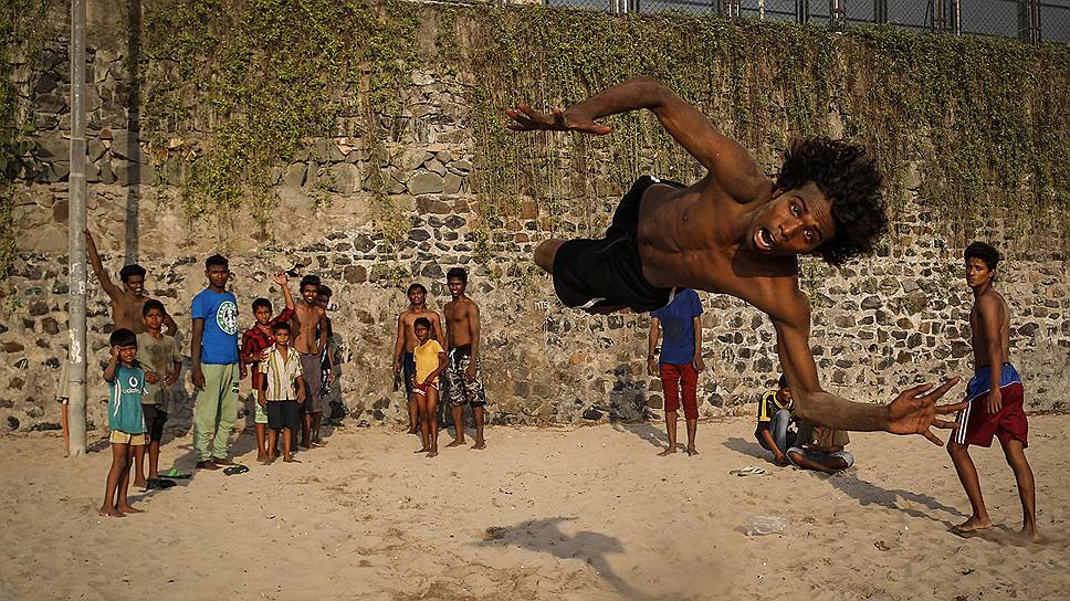 Член индийской уличной танцевальной труппы тренируется на пляже в Мумбаи