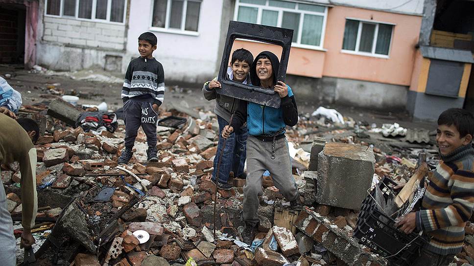 Болгарские цыгане позируют фотографам на руинах снесенных лачуг, незаконно построенных на окраине Пловдива