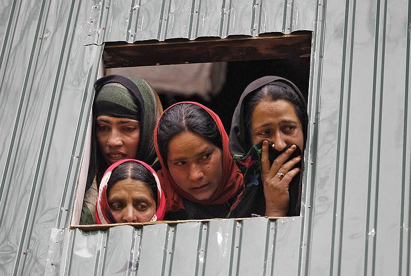 Родственники сотрудника избирательной комиссии, погибшего при атаке боевика на избирательный участок, во время похоронной церемонии в Херпоре, Кашмир