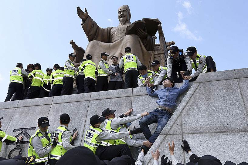 Задержание студентов у памятника Седжону Великому в Сеуле во время акции протеста, на которой демонстранты потребовали отставки президента Южной Кореи из-за крушения парома Sewol