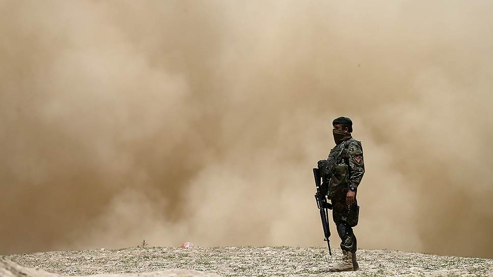 Солдат Афганской национальной армии во время взлета вертолета на месте оползня в районе Арго провинции Бадахшан