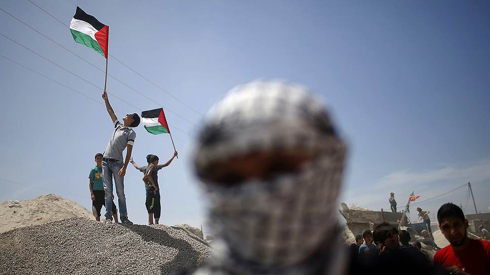 Палестинские активисты во время акции протеста по случаю 66-й годовщины Накбы, недалеко от границы восточной части Газы с Израилем