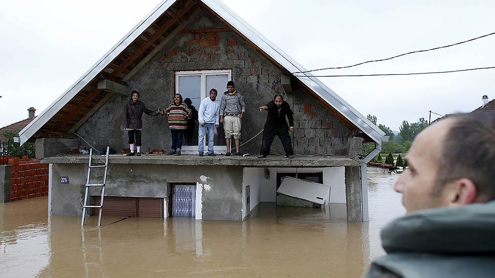 Люди стоят на чердаке своего затопленного дома и ждут эвакуации, город Обреновац, Сербия
