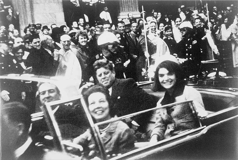21 ноября 1963 года Кеннеди с женой отправился в рабочую поездку по Техасу, в поддержку предвыборной кампании 1964 года. 22 ноября президентская чета поехала в кортеже в Торговый Аукционный зал, где Джон Кеннеди должен был выступить с речью во время обеда. Супруги Кеннеди (на двух задних сиденьях) и губернатор Техаса Джон Конналли с женой Нелли (на двух передних), ехали в кабриолете ближе к голове кортежа. На Элм-Стрит, в 12.30 по местному времени, Кеннеди был смертельно ранен выстрелом из винтовки. Описывая его визит в Даллас, журналисты писали: «Господина Кеннеди приветствовали восторженные жители, несмотря на предсказания о том, что в Далласе — этой цитадели правого республиканства — президенту будет оказан холодный прием»