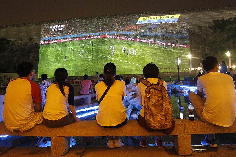Местные жители смотрят футбольную трансляцию в Китае