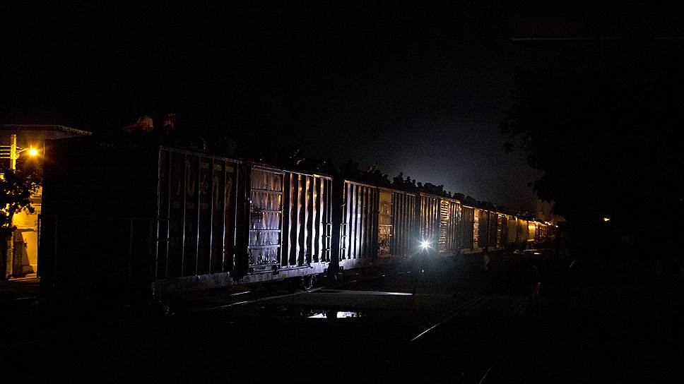 Мигранты едут на крыше грузового поезда, направляющегося на север из города Арриага, штат Чьяпас, Мексика