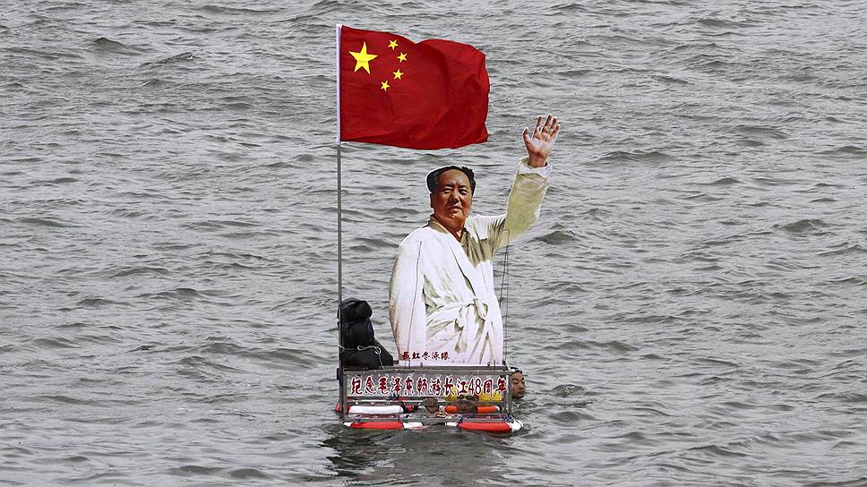 Китайцы с портретом Мао Цзэдуна и государственным флагом участвуют в праздничных мероприятиях, посвященных 48-й годовщине с того дня, когда Мао пересек реку Янцзы