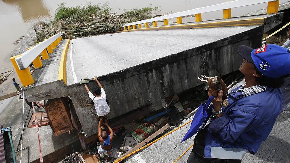 Жители города Батангас на Филиппинах на разрушенном во время тайфуна мосту