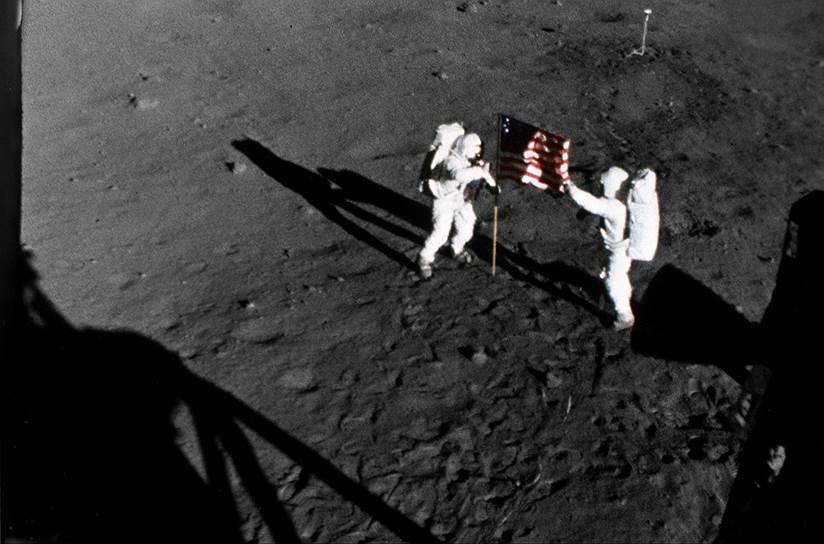Армстронг и Олдрин пробыли на Луне около трех часов. За это время они собрали 21,5 кг грунта, вышли на связь с президентом Никсоном и установили флаг США. Именно развевающееся полотнище позже стало поводом для упреков американцев в фальсификации: якобы в вакууме флаг должен был безжизненно повиснуть. Американцы объяснили, что флаг был закреплен на флагштоке, который слегка раскачивался. Кроме флага на Луне была установлена табличка  с выгравированными на ней словами: «Здесь люди с планеты Земля впервые ступили ногой на Луну. Июль, год 1969 от Рождества Христова. Мы пришли с миром от всего человечества»