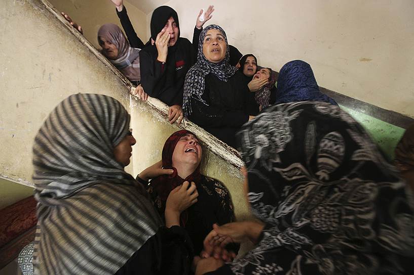 Скорбящие родственники палестинского боевика, погибшего при ударе израильской авиации в Секторе Газа