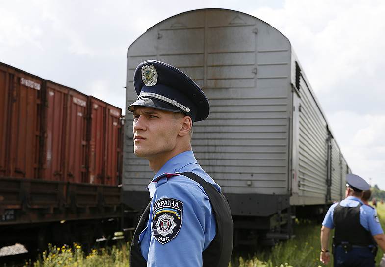 Сотрудники украинской милиции возле поезда с телами жертв крушения рейса MH17 авиакомпании Malaysia Airlines, прибывшего в Харьков