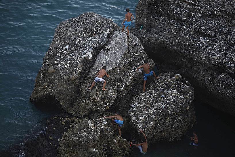 Дети на скалах у Средиземного моря в Нерхе, Испания