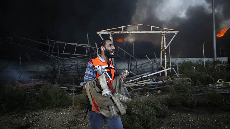 Палестинский пожарный на территории основной электростанции Газы, загоревшейся после израильской атаки