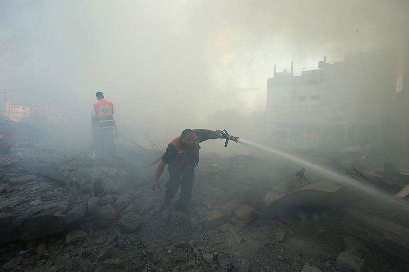 24.07.14. Палестинские пожарные борются с огнем после бомбардировок израильских ВВС