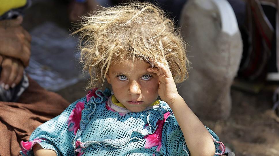 Девочка из езидской семьи, бежавшей от боевиков «Исламского государства» в Ираке, отдыхает возле КПП на иракско-сирийской границе в Фишхабуре
