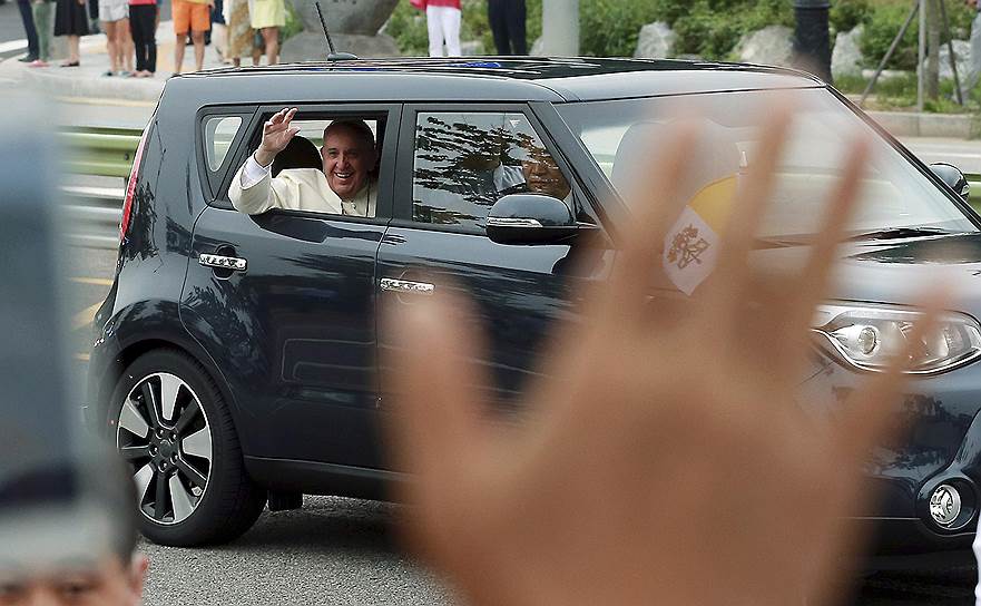 Папа римский Франциск приветствует людей во время своего визита в Сеул